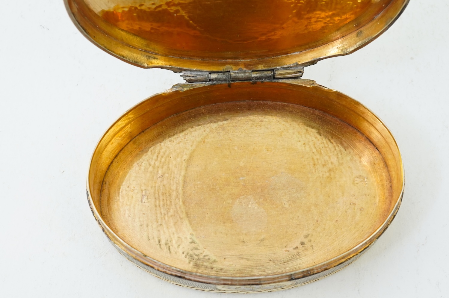 A 19th century Swiss? parcel gilt white metal oval snuff box with hinged cover